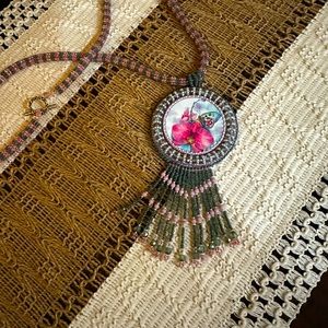 Hand beaded cabachon with beaded rope.
